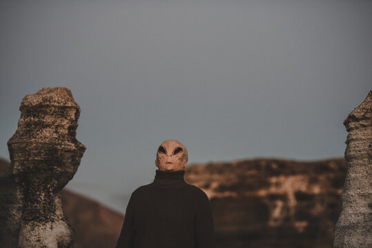 Portrait of alien head in a dark outdoors nature background. Concept of aliens among us. Extraterrestrial life. Creepy horror concept image. Life on earth and another planet discover science
