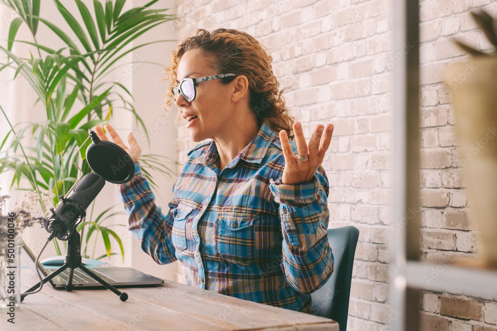 Wall mural young adult woman working at home with laptop and microphone. customer care and businesswoman job ac