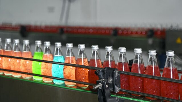 Colorful juice bottle in automatic production line machinery at bottling factory
