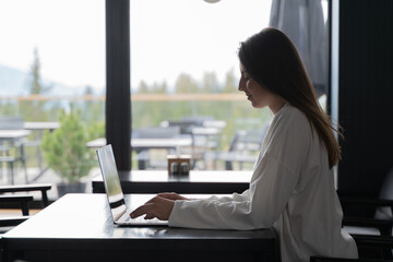 girl opens a laptop at a table in a cafe