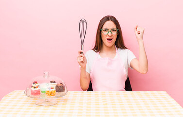 hispanic pretty woman shouting aggressively with an angry expression. home made cakes concept