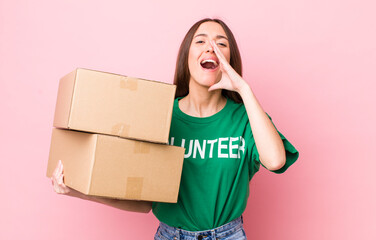 hispanic pretty woman feeling happy,giving a big shout out with hands next to mouth. volunteer...