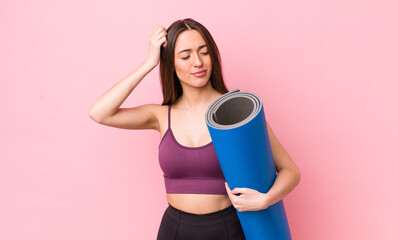 hispanic pretty woman smiling happily and daydreaming or doubting. fitness and yoga concept