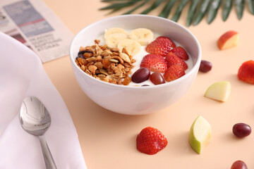 bowl of granola cereal with yogurt and berries isolated on eggnog color background