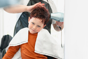 Faceless master drying hair of boy