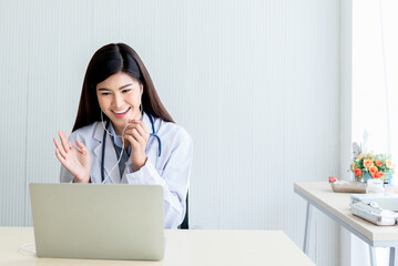 Asian attractive woman doctor Looking at and using a computer notebook To provide advice to patients By communication online, to health care and doctor online concept.