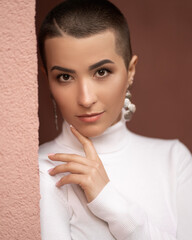 young sexy woman with short hair leaned against the wall