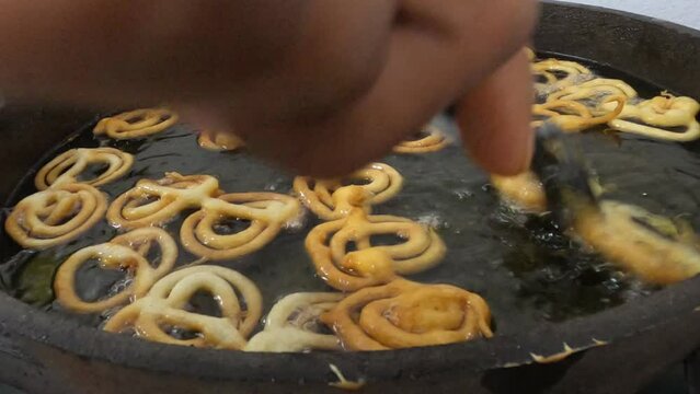 Raw jilapi deep frying 4k video clip.Jilapi making on a hot big pan.Jalebi, also known as jilapi, jilebi, jilipi, zulbia, jerry, mushabak, or zalabia, is a popular Indian sweet snack.