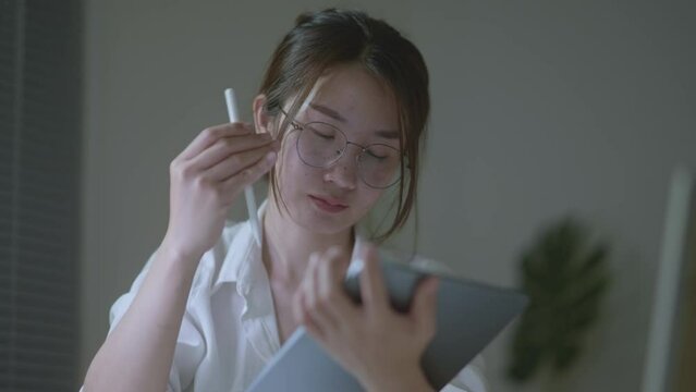 Young Beautiful business woman typing on iPad working at home. Working in room. Morning window light. Soft mood and soft focus.
