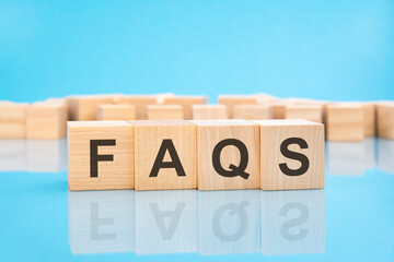 letters FAQS made with wood building blocks. blue background. business concept