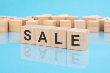 wooden blocks with the word Sale, blue background