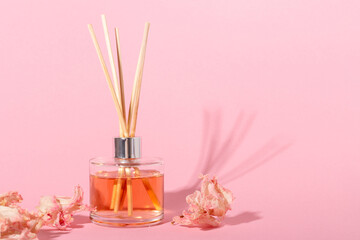 reed diffuser with flowers. Incense sticks for the home with a floral scent with hard shadows. The...