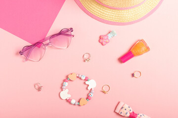 Baby accessories sunglasses and a hat on a pink background. Little girls accessories, flat lay