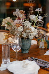 Wedding decor at the restaurant. Beautiful table setting with autumn flowers, orange and burning candles. Autumn wedding concept