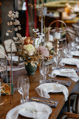 Wedding decor at the restaurant. Beautiful table setting with autumn flowers, orange and burning candles. Autumn wedding concept