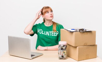 red head pretty woman feeling puzzled and confused, scratching head. Donation volunteer concept