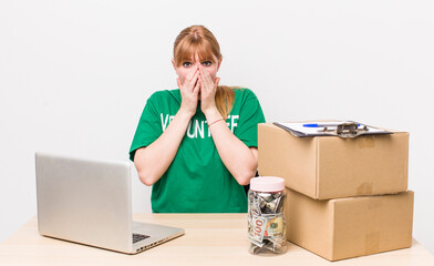 red head pretty woman covering mouth with hands with a shocked. Donation volunteer concept