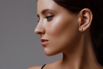 Close-up profile of a caucasian girl with perfect young fresh skin on a gray background. Facial...