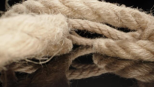 Jute rope on black table. Dolly slider extreme close-up. Laowa Probe