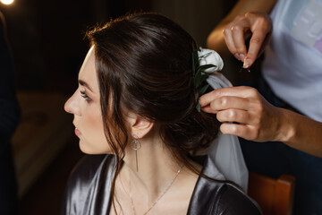 Fototapeta premium Bride in a dressing gown on the balcony. Young happy couple in love. The bride has dark hair and a long veil.