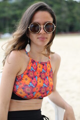 Beautiful woman on the beach with black sunglasses with beautiful background.