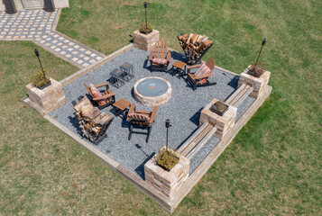 Aerial view of outdoor garden patio with gravel floor, wood fired fire pit, decorative torch for...