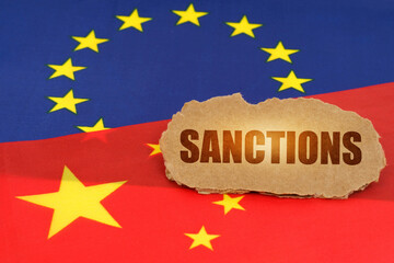 On the flags of China and the European Union lies a cardboard plate with the inscription -