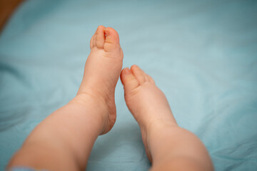 sweet little baby feet stretched out on bed