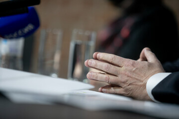 Businessman or politician giving inteview. Close up view gesticulating hands of business man.