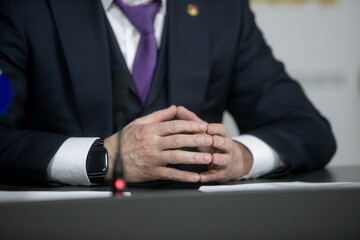 Businessman or politician giving inteview. Close up view gesticulating hands of business man.