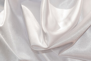 Close up of shiny white draped textile material.