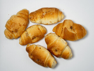 Many small croissants on a white background. Croissants with boiled condensed milk. Confectionery in the kitchen.