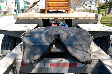 The massive "5th wheel" hitch on the back of a flat bed trailer designed to allow a second or "pony" trailer to be pulled by a single big rig truck tractor.