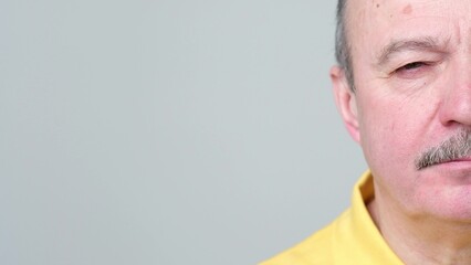 Fototapeta premium Half face of senior man without emotions. He is looking calm and confident