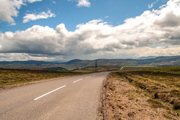 Typical rolling landscape of the Scottish Highlands in summer with blue skies and asphalt road