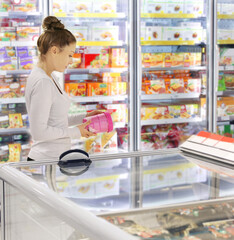 Woman choosing frozen food from a supermarket freezer.