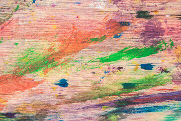 Close-up of abstract dirty painted wooden surface, paint of different bright colors