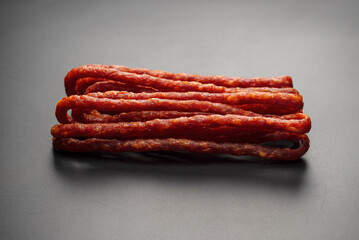Cabanossi, dry sausage isolated on black background.