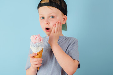 Sad boy eating ice cream and felt a sharp toothache. The child grabbed his cheek. dental care,...