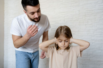 Upset kid girl closing ears not listening parent scolding at home, domestic violence, children and family problems concept