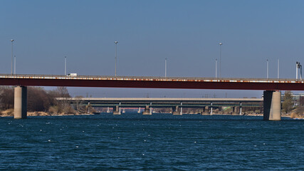 Fototapeta premium Diminishing perspective of the blue water surface of Danube River in the center of Vienna, Austria with several road bridges in a row on sunny day.