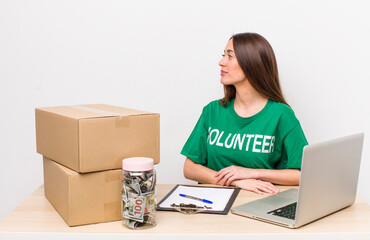 hispanic pretty woman on profile view thinking, imagining or daydreaming. donations volunteer