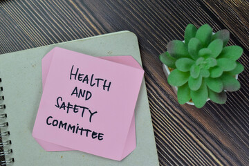 Health and Safety Committee write on sticky notes isolated on Wooden Table.