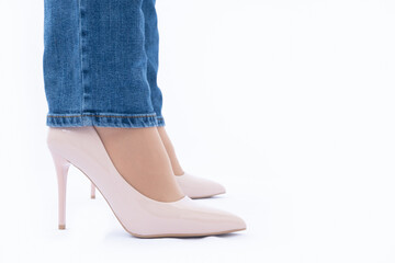 Slender female legs in high-heeled patent leather shoes. Blue jeans. Fashion and Style. side view