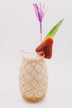 Cocktail de pi&ntilde;a colada servido en un vaso con forma de pi&ntilde;a
