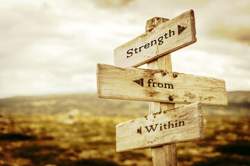 Fototapeta strength from within text quote written in wooden signpost outdoors in nature. Moody theme feeling. obraz