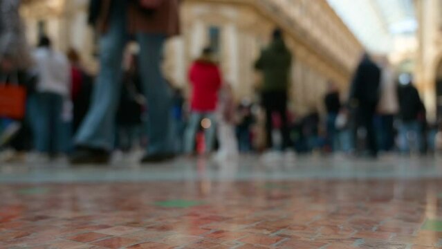 Milan, Italy, March 2022. Conceptual footage of the famous Vittorio Emanuele II gallery. In the blurred image the comings and goings of people crossing the gallery.