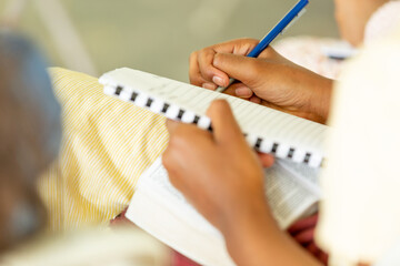 close up of a person writing on a notebook