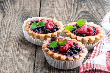 Delicious fruit tarts on wooden table