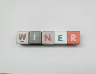 a series of letters in a children's toy puzzle block into the word winner